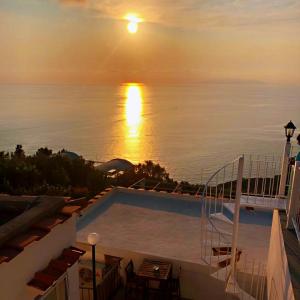 a swimming pool with the sun setting over the water at B&B La Danza del Mare in Anacapri
