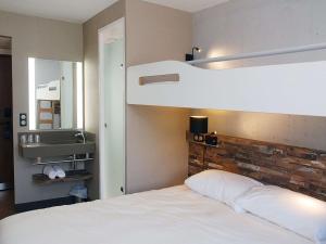 PoisyにあるIbis Budget Annecy sud-Poisyのベッドルーム1室(二段ベッド1組、白いベッドシーツ付)