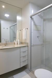 a white bathroom with a shower and a sink at #1 Sofisticado Estúdio na Boaventura da Silva in Belém