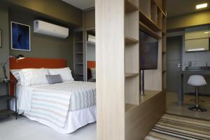 a bedroom with a bed and a wall with a tv at #1 Sofisticado Estúdio na Boaventura da Silva in Belém