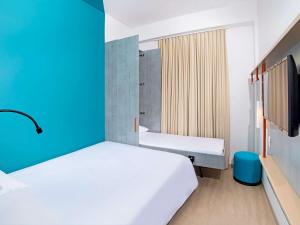 麦德林ibis budget Medellín Itagüí Metro的一间卧室，有两张床和一面蓝色的墙