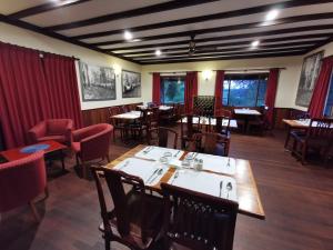 - une salle à manger avec des tables, des chaises et des fenêtres dans l'établissement Karri Forest Motel, à Pemberton