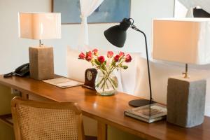 a desk with two lamps and a vase of flowers on it at Komaneka at Tanggayuda Ubud in Ubud