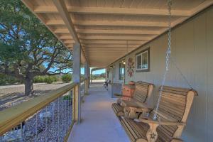 a porch swing hanging from the side of a house at Updated Cabin with Fire Pit - 1 Mile From Downtown! in Fredericksburg