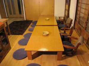 2 mesas largas en una habitación con sillas en Atami Ikyuan 熱海一休庵, en Atami