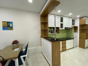 a kitchen and dining room with a counter and a table at Gold Ocean Apartment in Nha Trang
