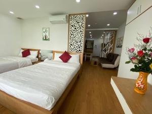 a bedroom with two beds and a vase of flowers at Gold Ocean Apartment in Nha Trang