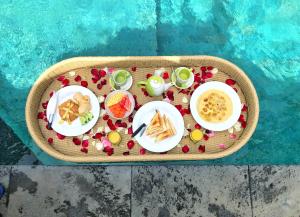 a tray of food on a table next to a pool at Ayu Bungalow 2 in Ubud