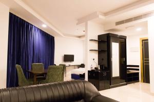 a living room with a couch and a table in a room at Parkside Plaza Muscat in Muscat