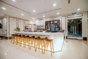 un bar con taburetes de madera en la cocina en Bella Vita Hotel, en Long Hai