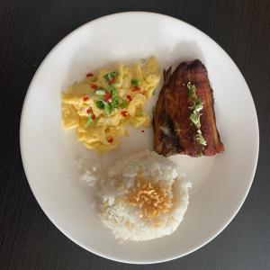 a white plate of food with rice and meat at Cebu R Resort Tabuelan in Tabuelan
