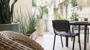 a black chair sitting next to a table on a patio at Fabulous and Quiet Apartment+Balcony in Barrio Norte. Your easy access to Buenos Aires! in Buenos Aires