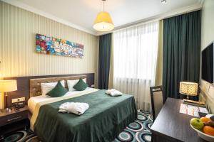 a hotel room with a bed with towels on it at Mildom Hotel in Almaty