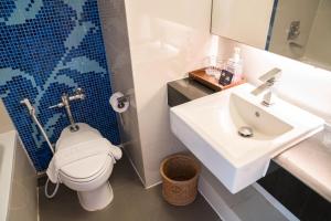 a bathroom with a white toilet and a sink at Grand Jomtien Palace Hotel - SHA Extra Plus in Jomtien Beach