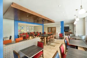 a dining room with tables and chairs in a restaurant at Holiday Inn Express & Suites S Lake Buena Vista, an IHG Hotel in Kissimmee