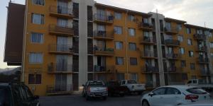 a large yellow building with cars parked in a parking lot at zpartment in Copiapó