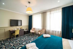 アルマトイにあるMildom Hotelのベッドと薄型テレビがあるホテルの部屋