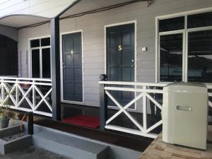 un porche delantero de una casa con puertas negras en Suhaila Palace, en Islas Perhentian