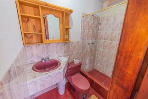 a bathroom with a red toilet and a sink at El Andariego in Otavalo