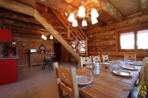a dining room with a table in a log cabin at Chalets de Fougerousse in Chambon-sur-Lac