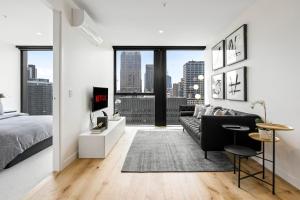 un soggiorno con letto e divano di Luxuria Apartments - Collins House a Melbourne