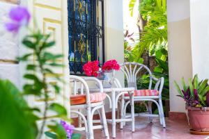 einen Tisch und Stühle auf einer Veranda mit Blumen in der Unterkunft Jacyjoka Apartments Nyali in Mombasa