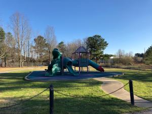 a playground with a slide in a park at Cozy cottage feel, 5 mins from Ft. Bragg in Fayetteville