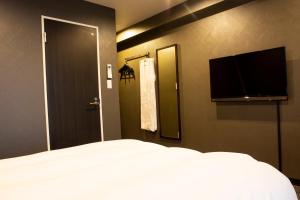 a bedroom with a bed and a flat screen tv at HOTEL PAR-MAN in Chiba