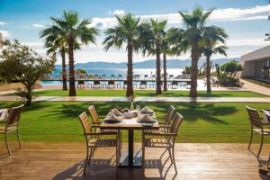 a table and chairs on a patio with palm trees at ON'LIVE HOTEL in Çeşme