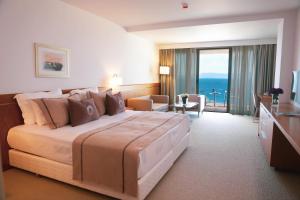 a hotel room with a large bed and a balcony at ON'LIVE HOTEL in Çeşme