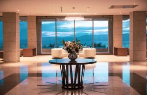 a lobby with a table with a vase of flowers on it at ON'LIVE HOTEL in Çeşme