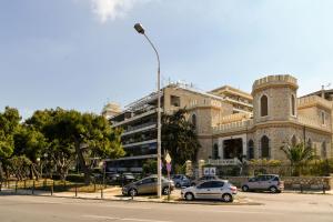 a building with cars parked in front of a street at Athens Sea view 2 floor apartment next to Marina in Athens