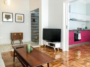 un salon avec une télévision et une table dans l'établissement Athens Sea view 2 floor apartment next to Marina, à Athènes