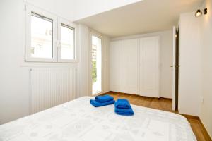 - une chambre avec un lit et des chaussons bleus dans l'établissement Athens Sea view 2 floor apartment next to Marina, à Athènes 27 autres photos