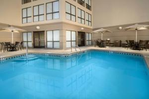 a large pool in a hotel with tables and chairs at Holiday Inn El Paso Airport, an IHG Hotel in El Paso
