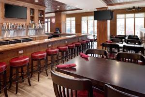 un restaurante con bar con taburetes rojos en Holiday Inn Trophy Club, an IHG Hotel, en Trophy Club