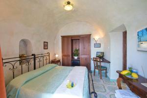 a bedroom with a bed and a desk in a room at L'Antico Borgo Dei Limoni in Amalfi