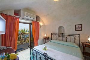アマルフィにあるランティコ ボルゴ デイ リモーノのベッドルーム(ベッド1台付)、バルコニーが備わります。