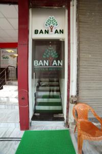 a store front with a green floor and a chair in front at Banyan hotel&restro in Hisār