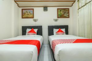 A bed or beds in a room at OYO 2580 Hotel Puri Royan