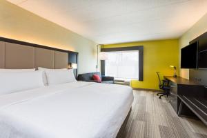 a hotel room with a large bed and a tv at Holiday Inn Express - Lorton, an IHG Hotel in Lorton