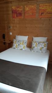 a bedroom with a white bed with pillows at Art Hotel Tendance in Limoges