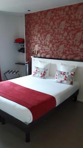 a bedroom with a large bed with a red wall at Art Hotel Tendance in Limoges