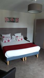 a bedroom with a large bed with red and white pillows at Art Hotel Tendance in Limoges