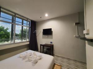 a hotel room with a bed with two white towels at De Chukai Hotel in Kampong Kemaman