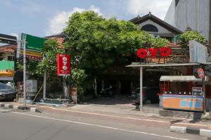 a street with a tree in front of a building at OYO 2580 Hotel Puri Royan in Denpasar
