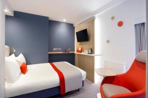 een hotelkamer met een bed en een rode stoel bij Holiday Inn Express Southwark by IHG in Londen +35 foto's