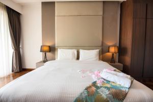 a bedroom with a large white bed with two lamps at The Landmark by Katana in George Town