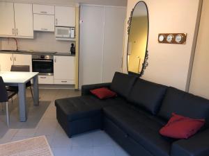 a living room with a black couch and a table at Prinses Elisabeth in Koksijde