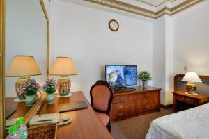 a room with a desk with two lamps and a bed at The Spring Hotel in Ho Chi Minh City